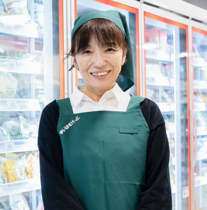 笑顔で正面を向くE.K.さん（シニアスタッフ）のインタビュー写真