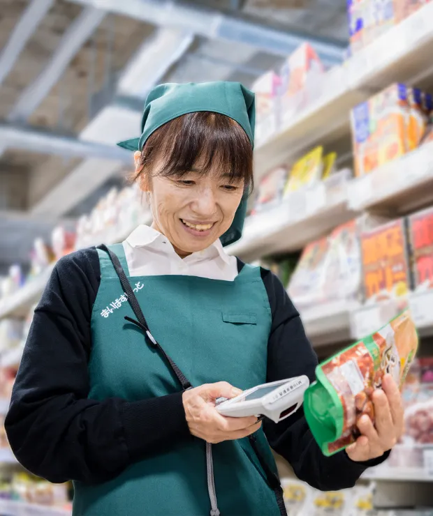 シニアスタッフのE.K. さんがレジで接客対応をしている様子