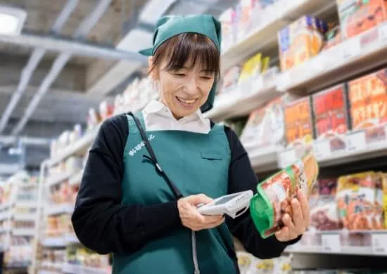 シニアスタッフのE.K. さんがレジで接客対応をしている様子