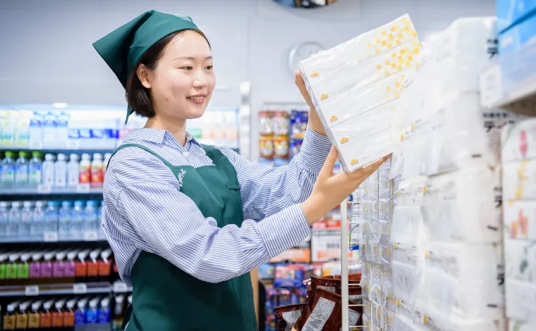 留学生スタッフのR.A.さんが商品を棚に陳列している様子