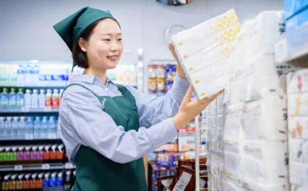 留学生スタッフのR.A.さんが商品を棚に陳列している様子