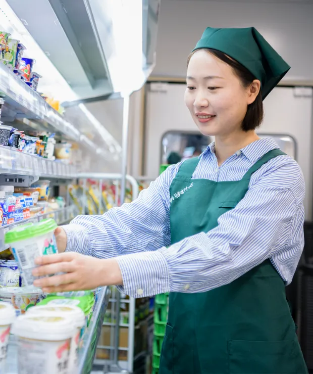 留学生スタッフのR.A.さんが商品を棚に陳列している様子